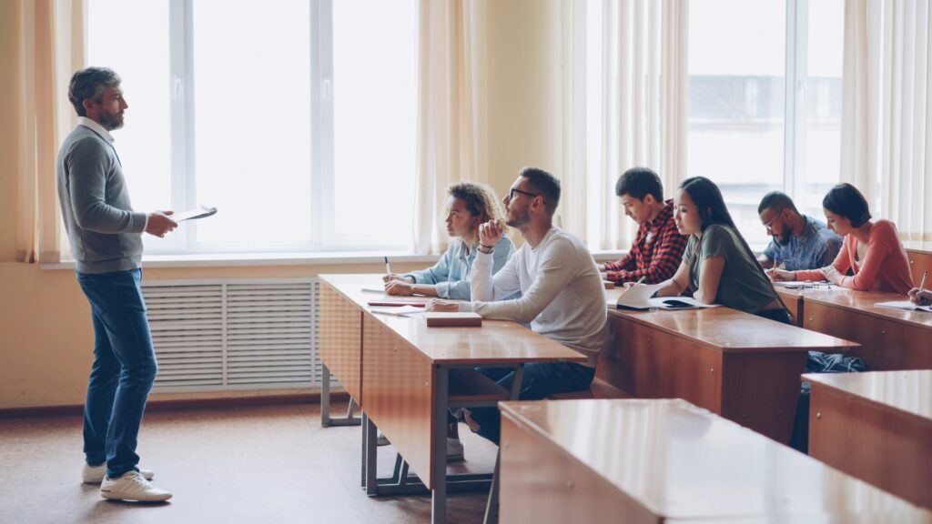 College students sitting and receiving a lecture from a male lecturer