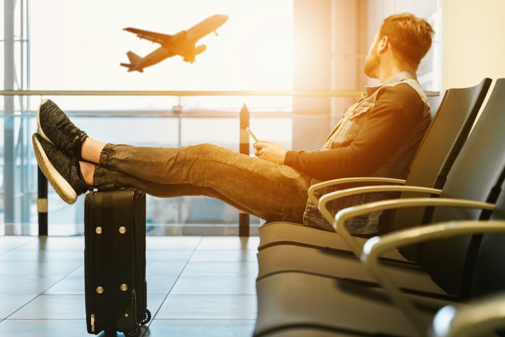 A guy travelling by air sitting and waiting at the airport